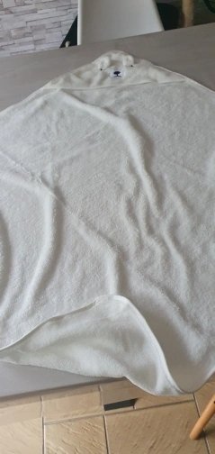 Customer photo: a cream hooded baby towel laid flat on a table