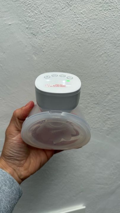 Customer photo: a hand holding a wearable pump against a white wall