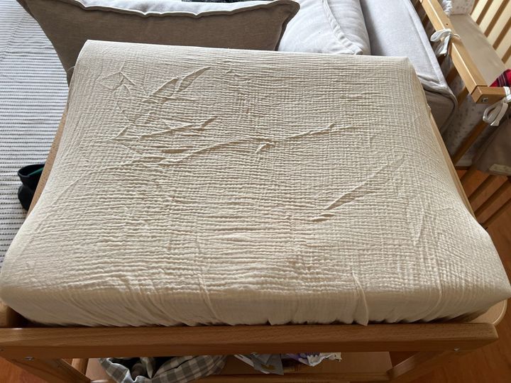 Customer photo: the cream muslin cover fitted on a changing pad