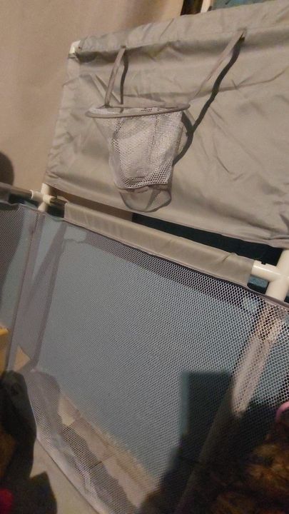 Customer photo: close-up of the mini basketball hoop and mesh wall of the grey playpen