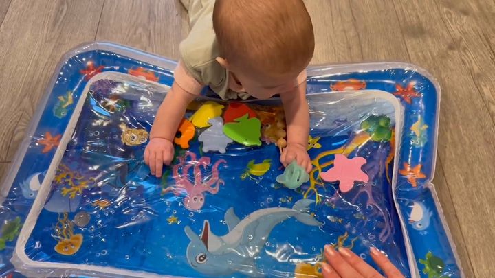 Real-life look-alike: a baby pressing both hands on a water mat during tummy time