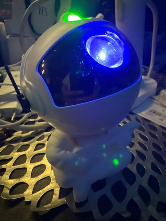 Customer photo: the astronaut projector glowing blue in a dark room