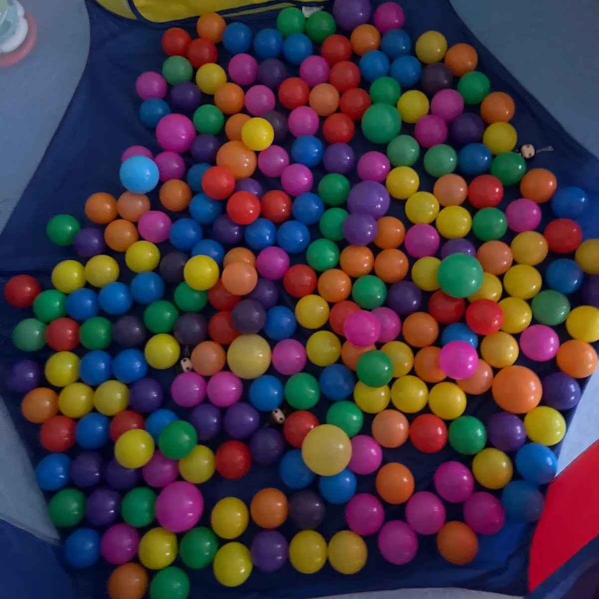 Play tent filled with mixed-color ball pit balls