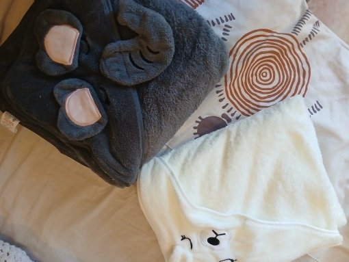 Customer photo: two hooded baby towels folded on a bed
