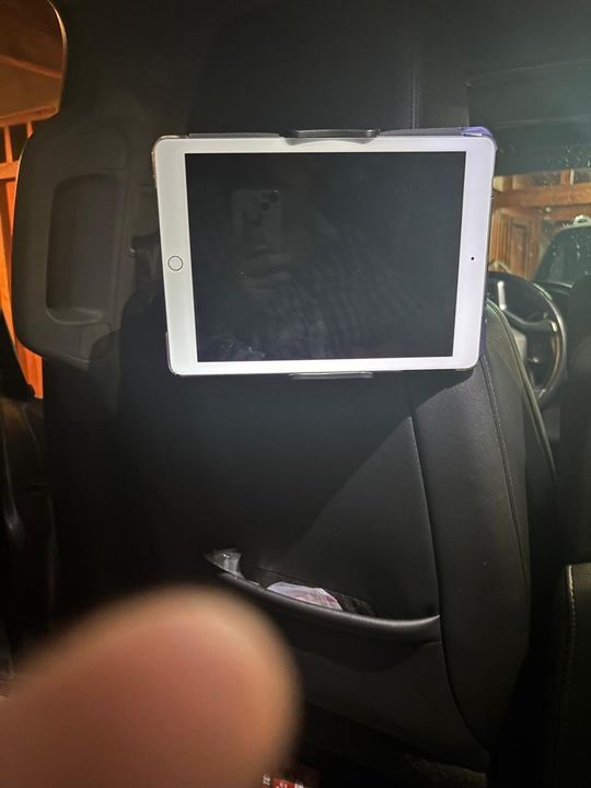 Customer photo: a tablet held by the mount on the back of a car seat