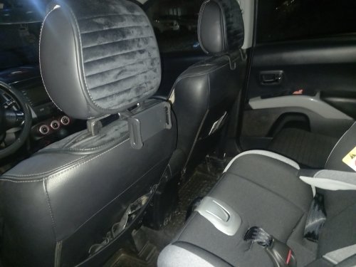 Customer photo: the mount attached to the headrest posts of a car seat