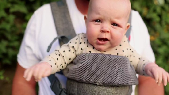 Man wearing the carrier with a baby facing outward