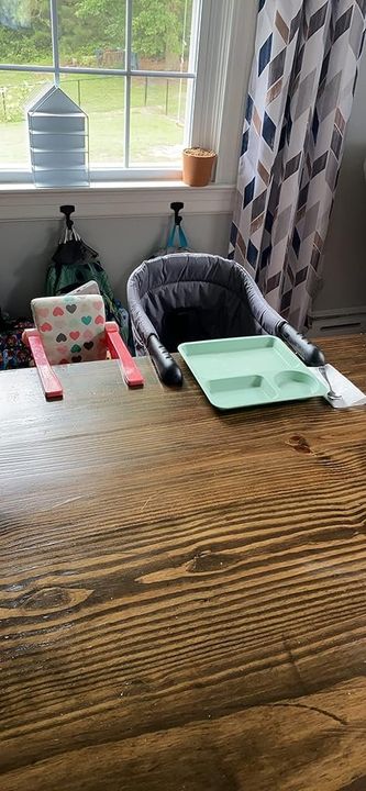 Customer photo: the grey clip-on dining chair attached to a table, set for a meal