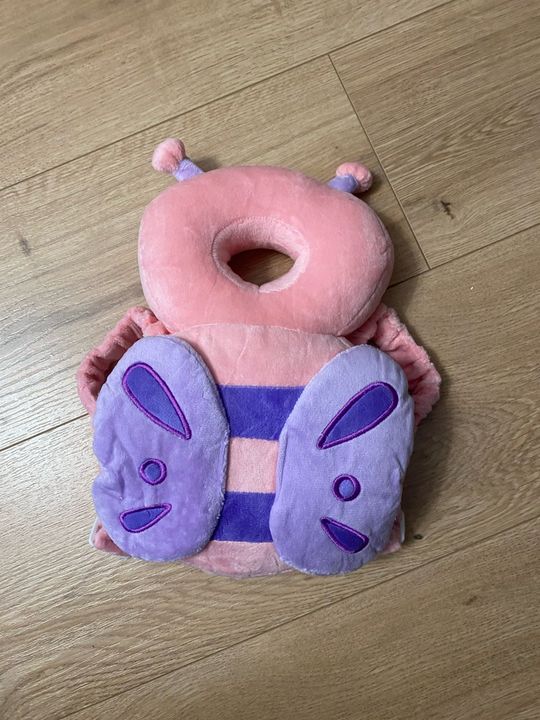 Customer photo: the butterfly design pillow lying flat on a wooden floor