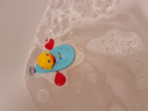 Customer photo: the duck kayak toy floating in a bathtub among soap bubbles