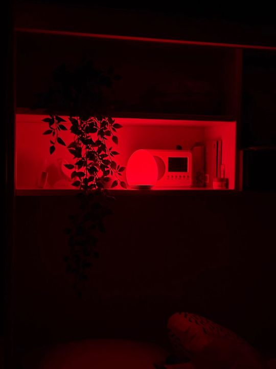 Customer photo: the lamp on a shelf glowing red in a dark room