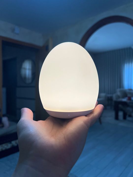 Customer photo: a hand holding the lamp glowing bright white