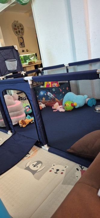 Customer photo: the blue playpen set up on a foam play mat with soft toys