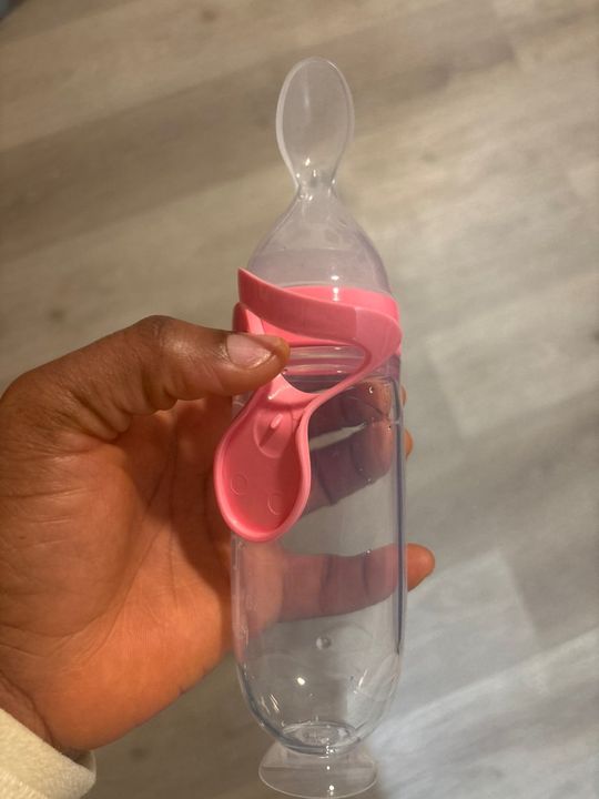 Customer photo: a hand holding the feeder with a pink collar