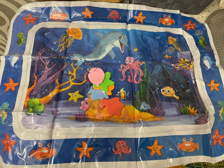 Customer photo: the water play mat with its floating sea-creature shapes on a carpet